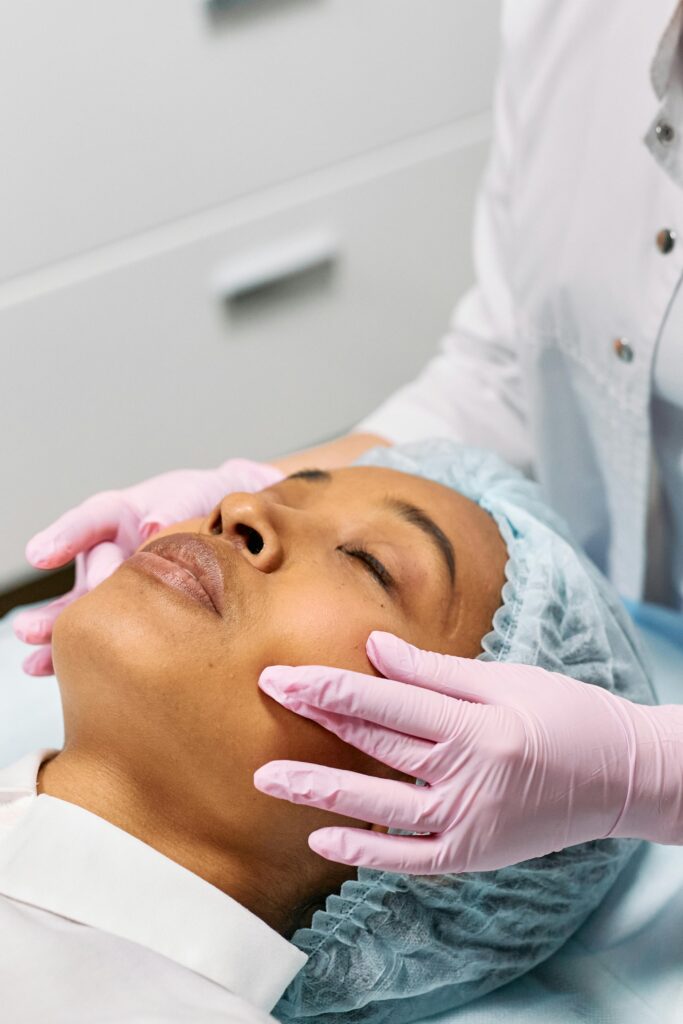 A woman receiving a facial treatment at a spa with a beautician wearing gloves.