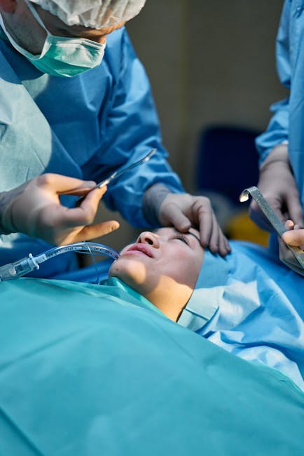 Doctors and nurses conduct a medical procedure in an operating room setting, focusing on patient care.